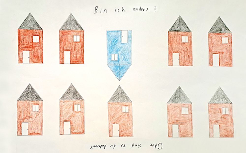 Foto zeigt eine Zeichnung mit mehreren roten Häusern und einem blauen Haus, das als einziges auf dem Kopf steht. Der Titel des Bildes lautet "Bin ich anders oder sind es die Anderen?"