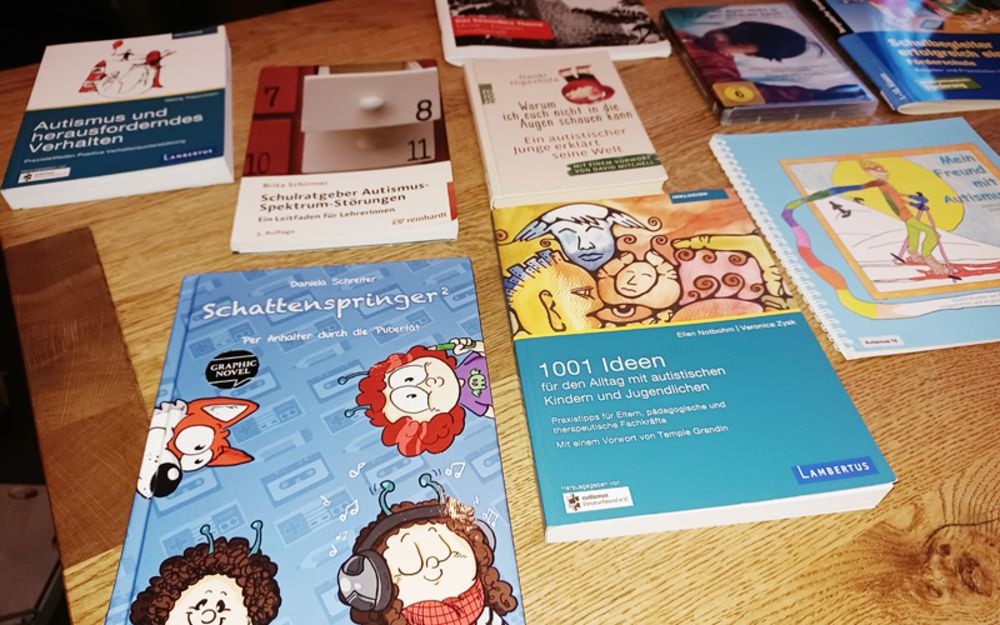 Foto zeigt mehrere Bücher über Autismus, die auf einem Tisch liegen