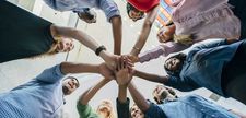 Foto zeigt Gruppe von Menschen, die sich an den Händen fassen