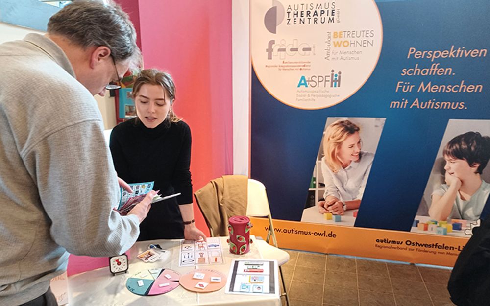 Foto zeigt Olaf Hanke (Bereichsleitung ATZ Lippe) und Mitarbeiterin Judith Schlüter (ATZ Bielefeld) im Gespräch am Infostand