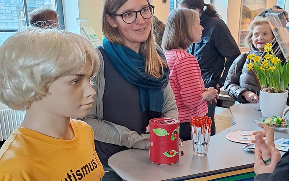 Foto zeigt Lara Bäthge (Therapeutin ATZ Bielefeld-Mitte) am Infostand des Vereins autismus OWL e.V.