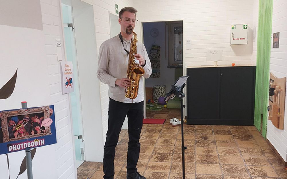 Foto zeigt Mitarbeiter Andreas Zymny beim Saxophon spielen.