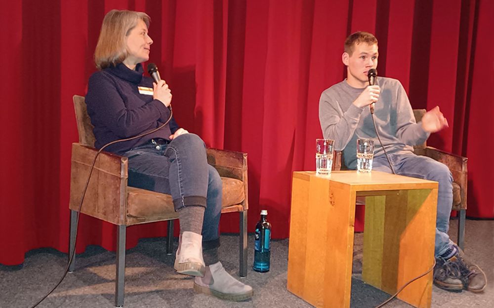 Foto zeigt Therapeutin aus dem ATZ Bielefeld Bettina Mester mit ihrem ehemaligen Klienten Robert Pähler auf der Kinobühne während der Publikumsdiskussion