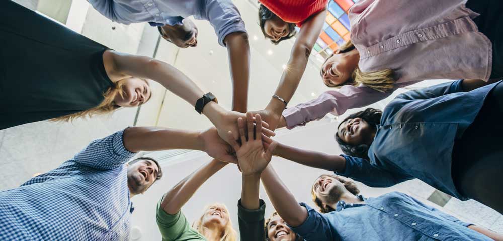 Gruppenfoto Menschen reichen sich die Hand