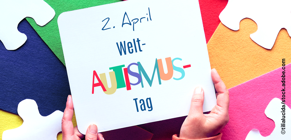 Foto zeigt Schild mit Händen, die ein Schild mit Aufschrift "2. April Welt-Autismus-Tag" halten